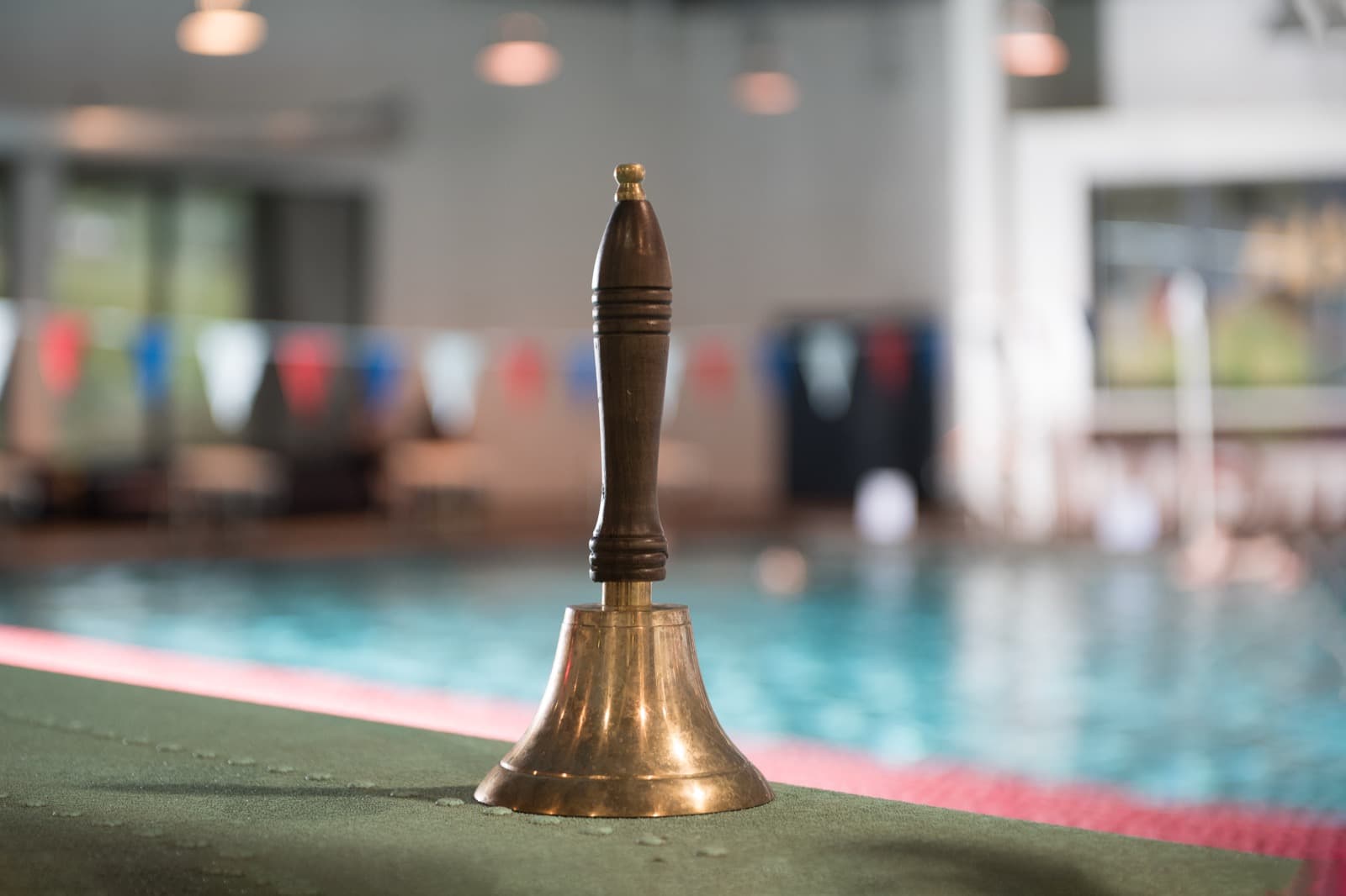 Young swimmer ringing the bell after passing a level at OCSS